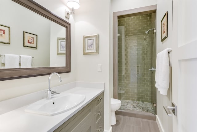 bathroom featuring vanity, a shower with shower door, toilet, and tile patterned floors