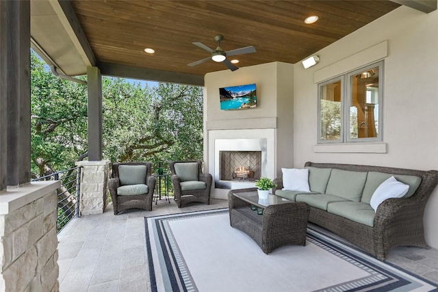 view of patio / terrace featuring an outdoor living space with a fireplace and a ceiling fan