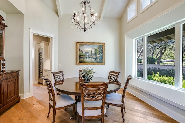 dining space with light wood finished floors, beam ceiling, and a wealth of natural light