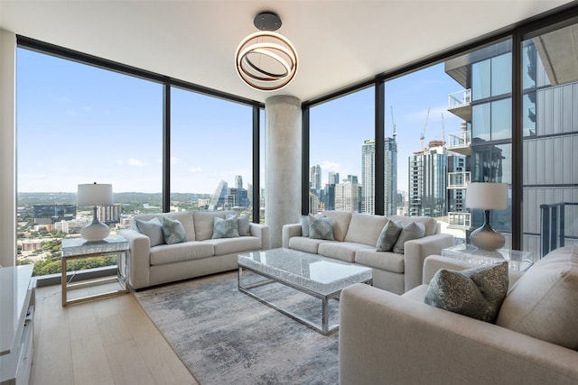 living room featuring wood-type flooring, a wall of windows, and plenty of natural light