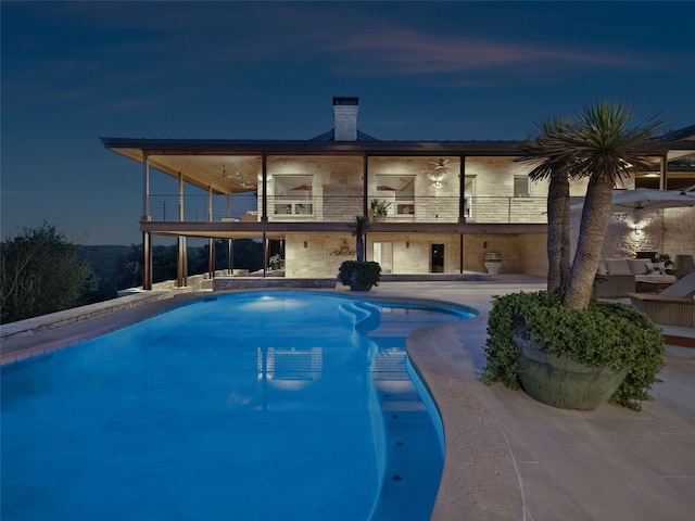 pool at twilight with a patio area