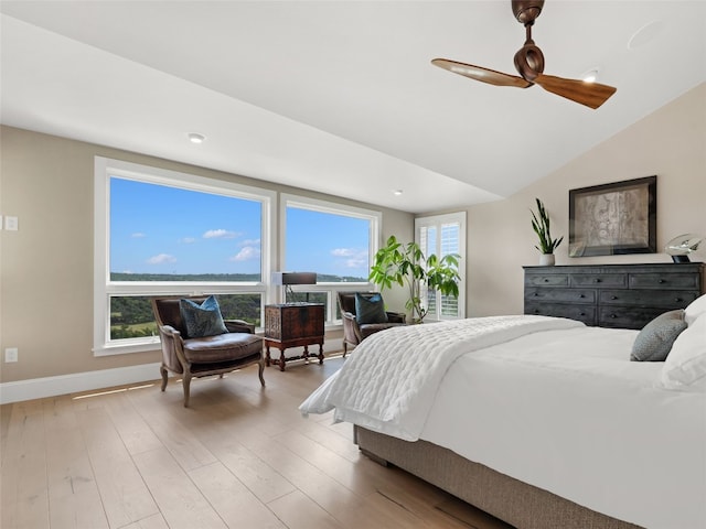 bedroom with multiple windows, lofted ceiling, ceiling fan, and light hardwood / wood-style flooring