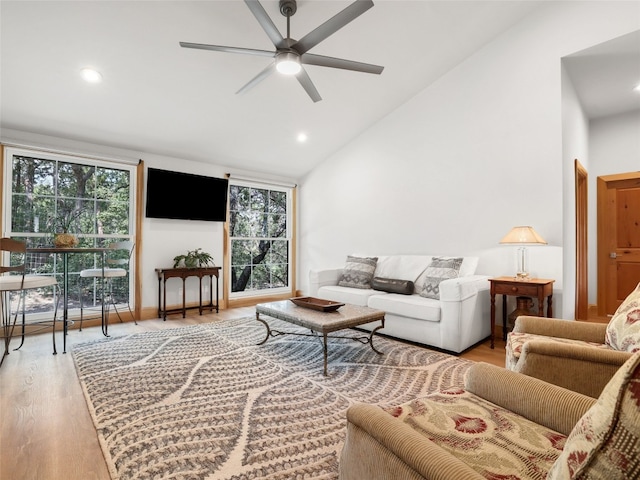 living room featuring ceiling fan, light wood-type flooring, and high vaulted ceiling