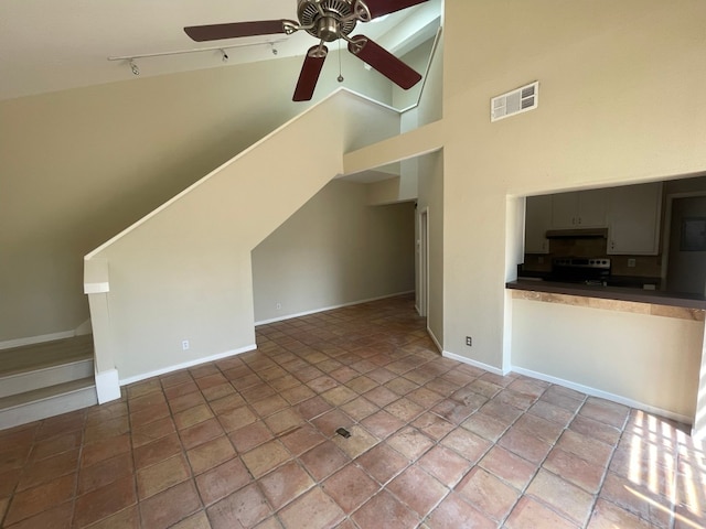 unfurnished living room featuring high vaulted ceiling and ceiling fan