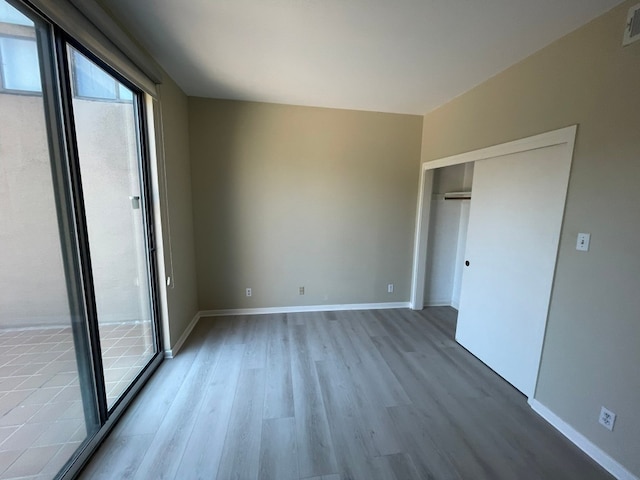 unfurnished bedroom featuring light wood-type flooring and a closet