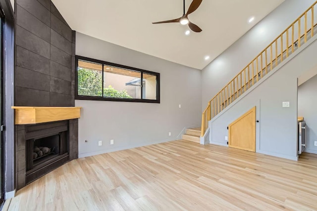 1707 Spyglass Dr Unit 60, Austin, TX 78746 - unfurnished living room featuring a ceiling fan, wood finished floors, stairway, a large fireplace, and recessed lighting