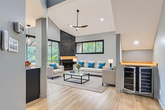 1707 Spyglass Dr Unit 60, Austin, TX 78746 - living area featuring beverage cooler, light wood-style floors, high vaulted ceiling, a dry bar, and a large fireplace