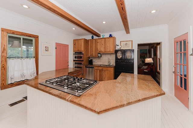 kitchen featuring beamed ceiling, kitchen peninsula, sink, tasteful backsplash, and appliances with stainless steel finishes