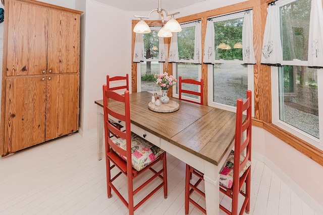 dining space with light hardwood / wood-style flooring and a chandelier