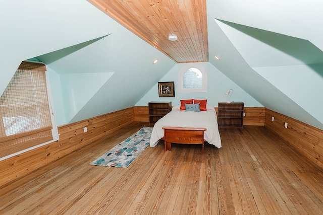 bedroom with wood ceiling, lofted ceiling, wood walls, and hardwood / wood-style flooring