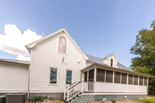 back of house with a sunroom and central AC