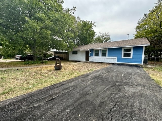 ranch-style home featuring a front lawn