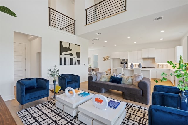 living room with a high ceiling and light hardwood / wood-style flooring