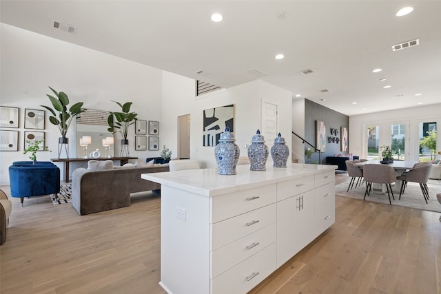 kitchen featuring white cabinets, light hardwood / wood-style floors, and a kitchen island