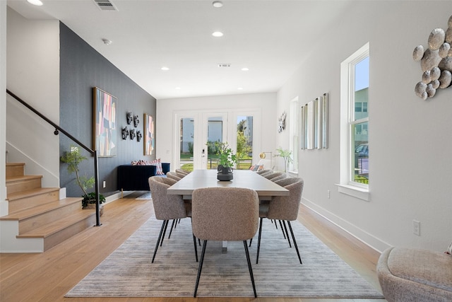 dining room with french doors and light hardwood / wood-style flooring