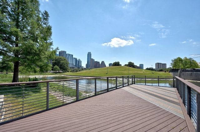 wooden deck with a water view and a yard