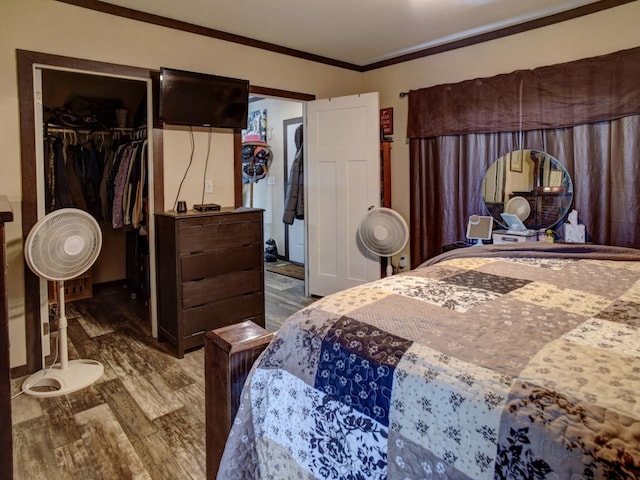 bedroom with a closet, hardwood / wood-style floors, and crown molding