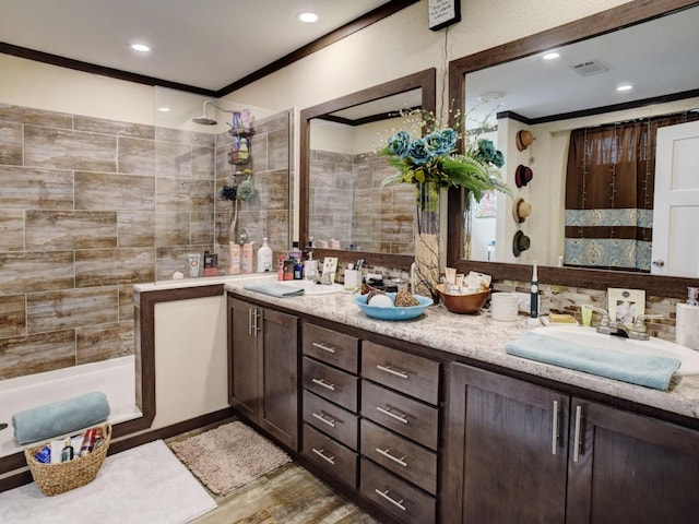 bathroom with vanity, crown molding, a tile shower, and hardwood / wood-style flooring