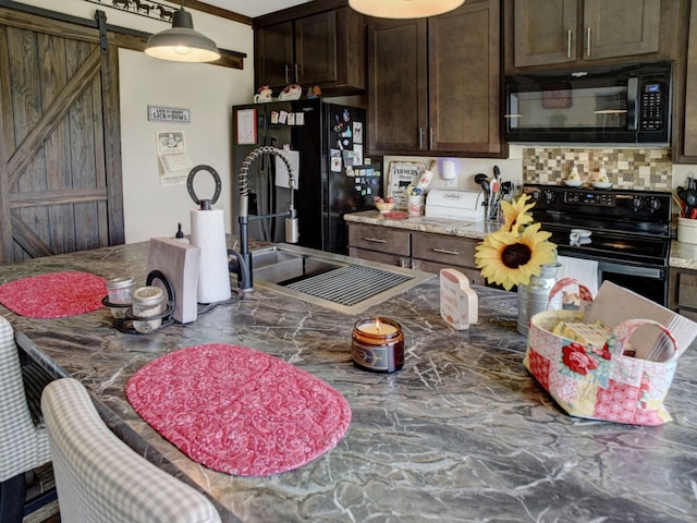 kitchen with sink, tasteful backsplash, dark brown cabinets, black appliances, and a barn door