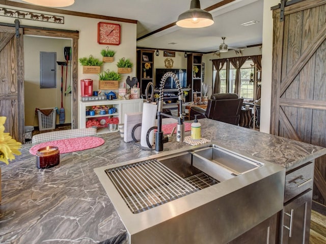 kitchen featuring a barn door, ornamental molding, and ceiling fan