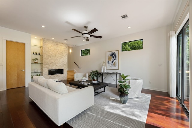 living room with ceiling fan, a fireplace, and dark hardwood / wood-style flooring