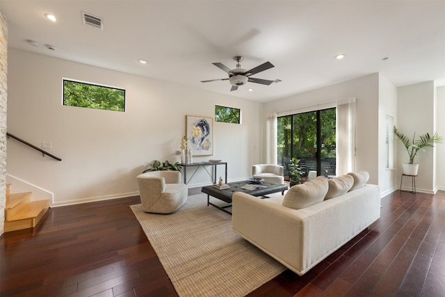 living room featuring dark wood-type flooring and ceiling fan