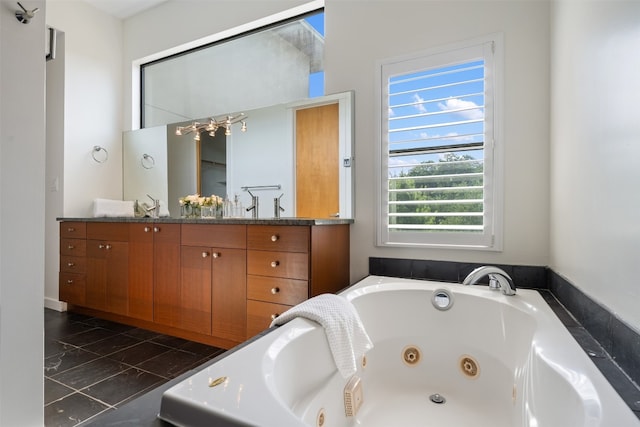 bathroom featuring tiled tub, vanity, and tile patterned floors