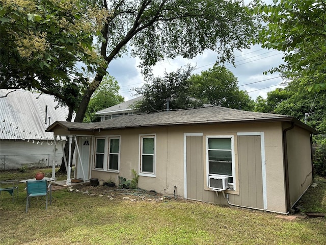 rear view of house with cooling unit and a yard