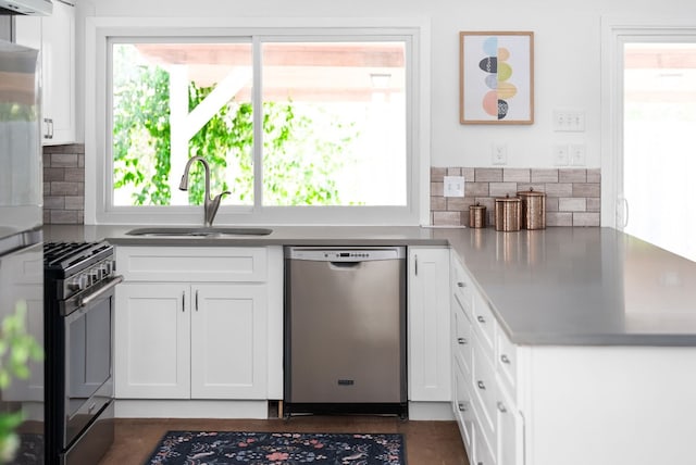 kitchen featuring white cabinetry, tasteful backsplash, stainless steel appliances, ventilation hood, and sink