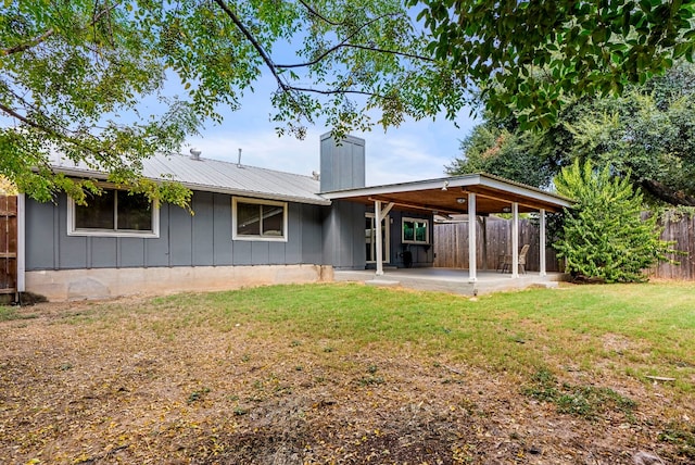 back of house with a patio area and a yard