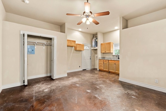 interior space with ceiling fan, water heater, and sink