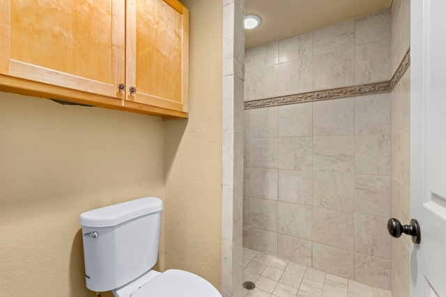 bathroom with toilet and tiled shower