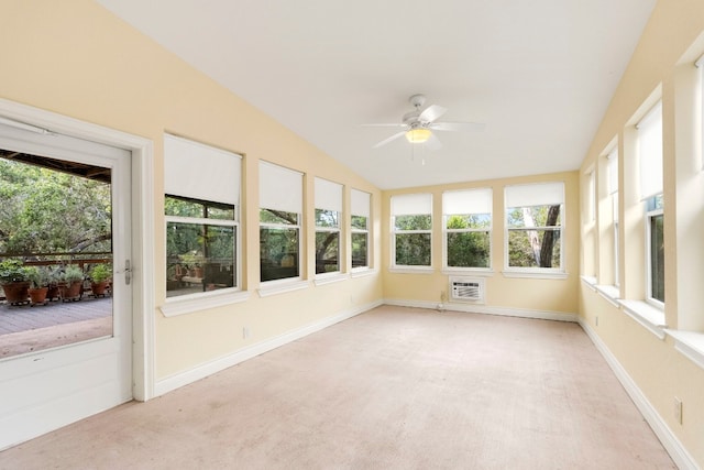 unfurnished sunroom with a healthy amount of sunlight, vaulted ceiling, ceiling fan, and a wall mounted air conditioner