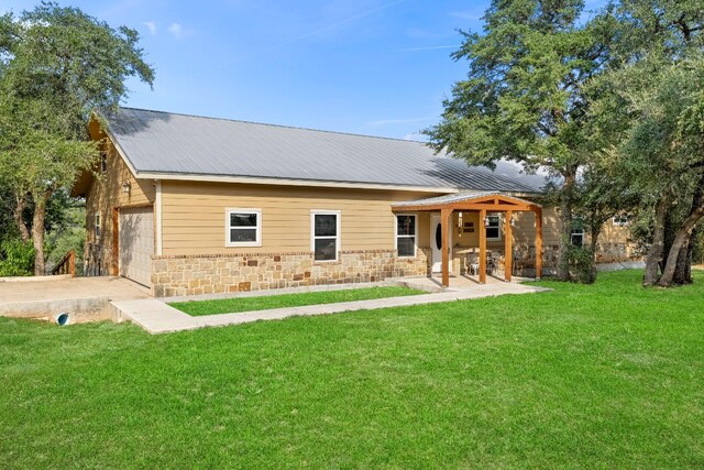 back of property featuring a yard and a garage