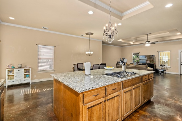 kitchen featuring ceiling fan with notable chandelier, a center island, stainless steel gas stovetop, and crown molding