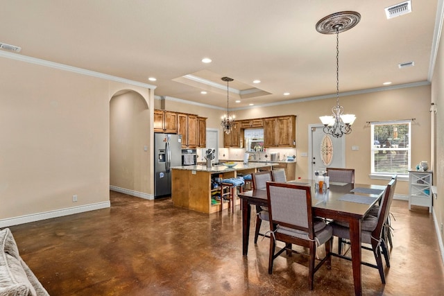 dining area featuring crown molding, sink, and a chandelier