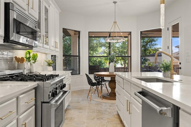 15009 General Williamson, Austin, TX 78734 - kitchen with stainless steel appliances, a sink, decorative backsplash, stone tile flooring, and light countertops