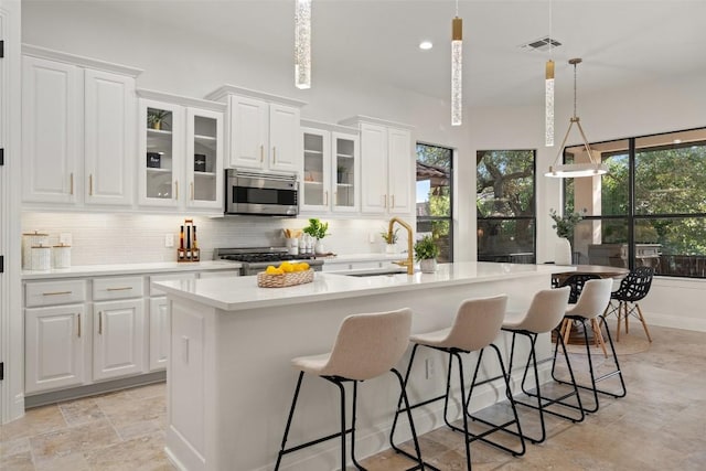 15009 General Williamson, Austin, TX 78734 - kitchen featuring stainless steel microwave, a sink, stove, light countertops, and decorative backsplash
