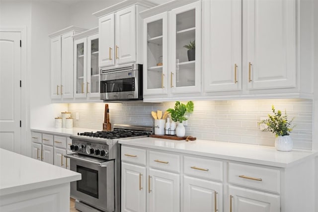 15009 General Williamson, Austin, TX 78734 - kitchen with appliances with stainless steel finishes, white cabinets, backsplash, light countertops, and glass insert cabinets