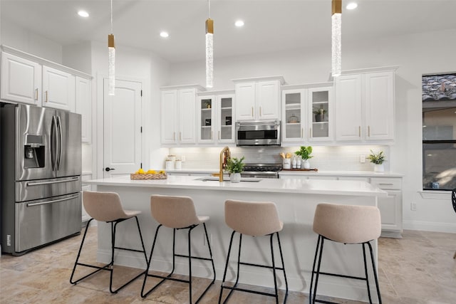 kitchen featuring a center island with sink, white cabinetry, sink, and appliances with stainless steel finishes