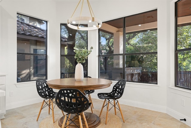 dining space featuring an inviting chandelier and baseboards