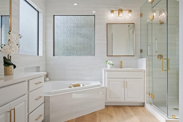15009 General Williamson, Austin, TX 78734 - bathroom with tile walls, a stall shower, two vanities, a bath, and wood finished floors