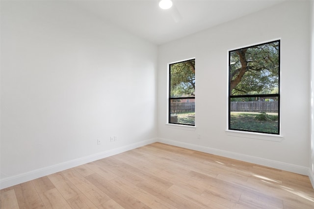 spare room featuring light wood-style floors, baseboards, and a ceiling fan