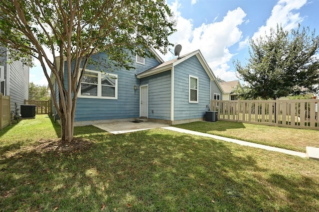 rear view of property with cooling unit, a lawn, and a patio