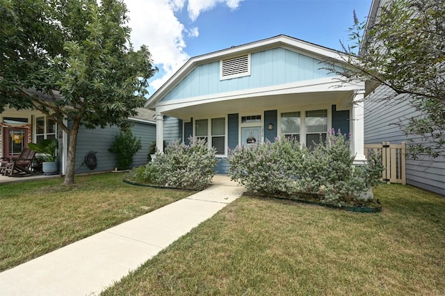 view of front of home with a porch and a front lawn