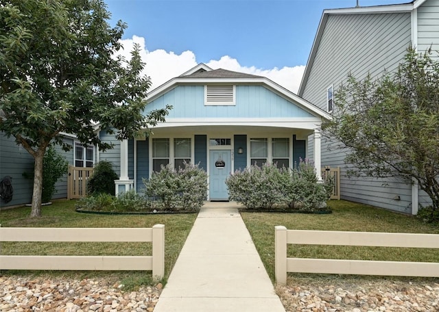 bungalow with a front yard and a porch