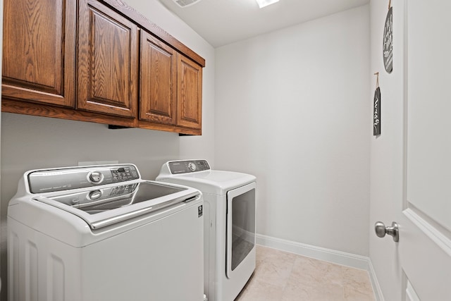 laundry room with separate washer and dryer, cabinets, and light tile patterned flooring