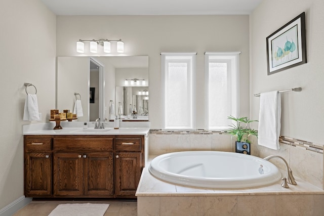 bathroom with tile patterned floors, a relaxing tiled tub, and vanity