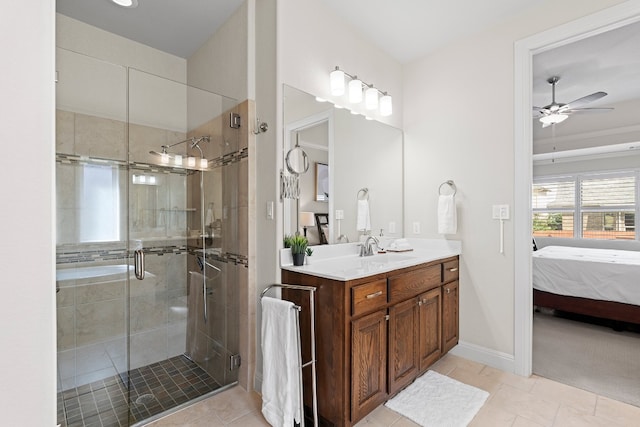 bathroom with ceiling fan, vanity, a shower with door, and tile patterned floors