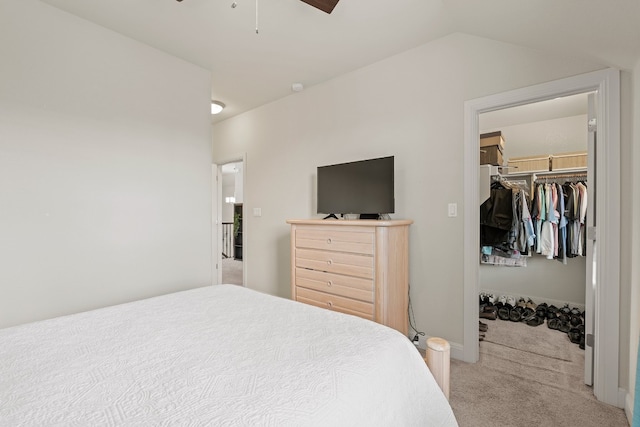 carpeted bedroom with ceiling fan, a closet, a spacious closet, and lofted ceiling